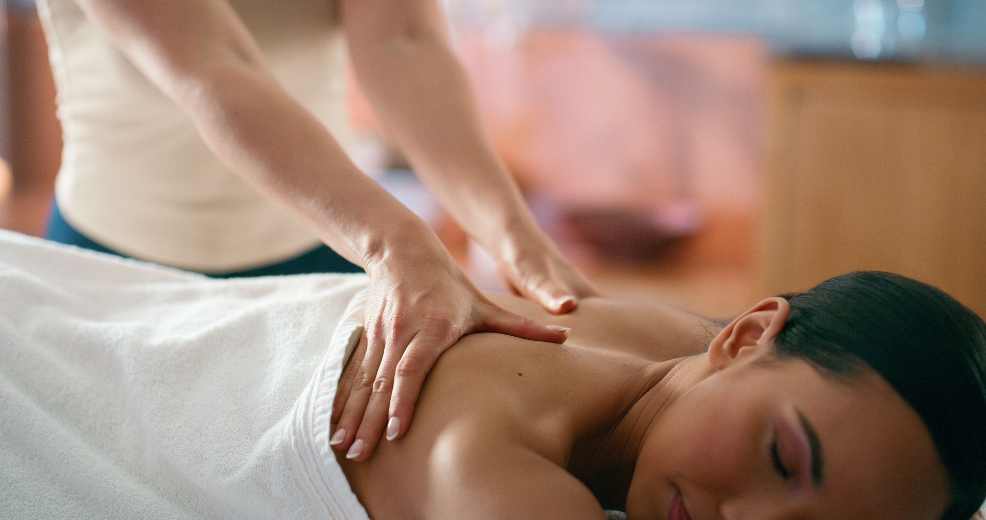 Woman, hands and back massage in hotel for wellness, muscle tension and stress relief with service of masseuse. Female person, peace and therapeutic healing in spa for relax, treatment and self care